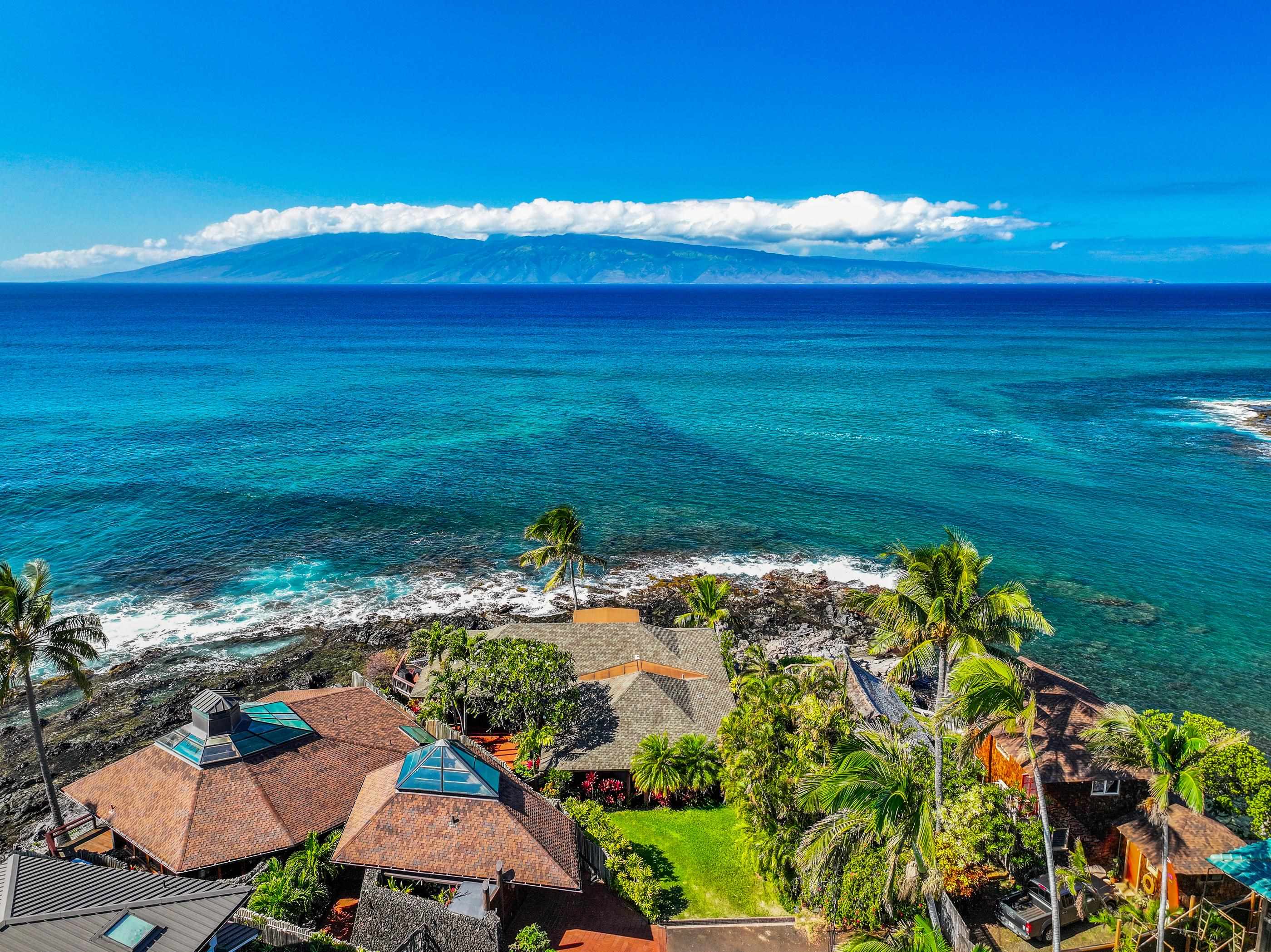 Elevated view over the rooftops of the point, the reef glowing turquoise beyond