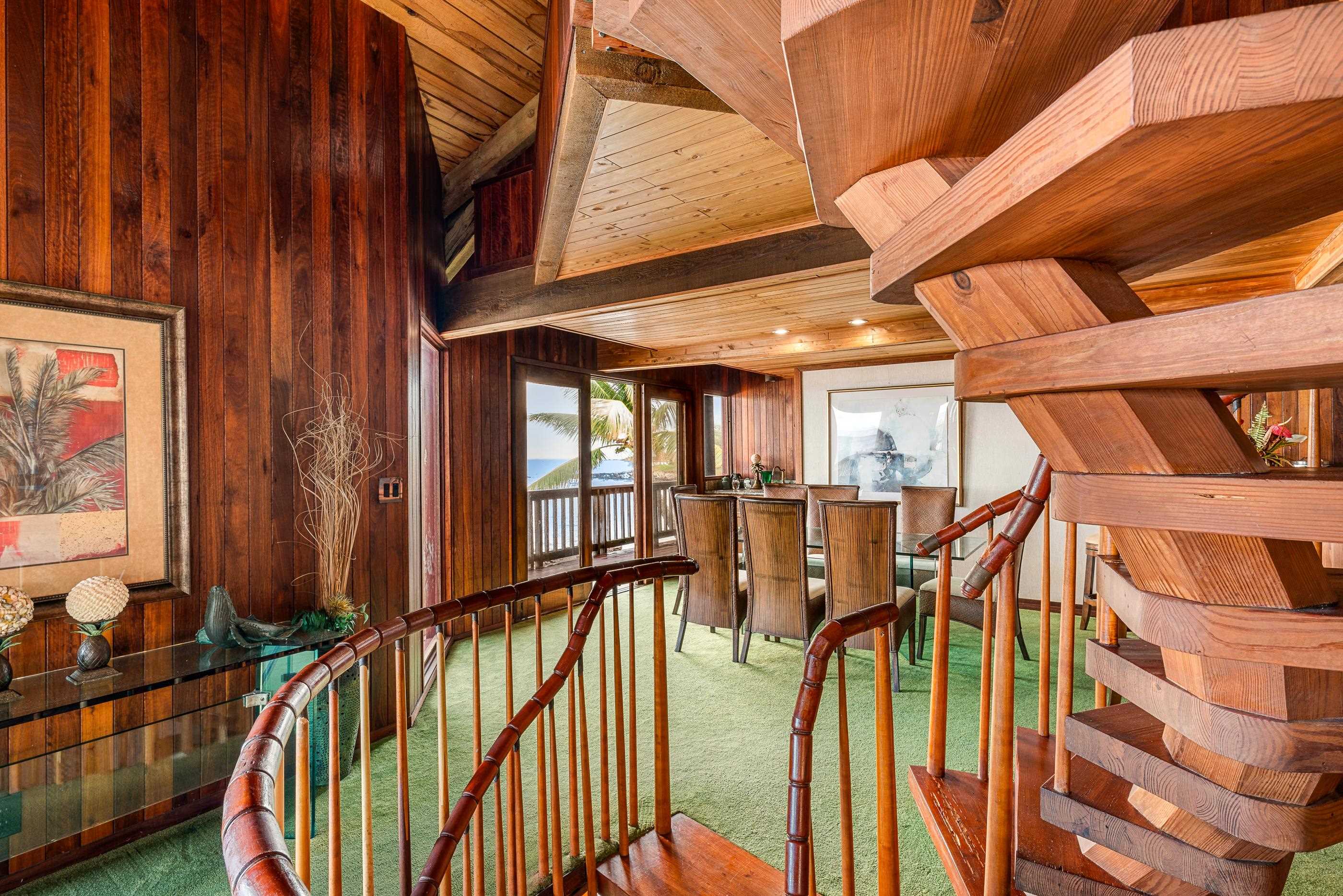 The handcrafted spiral staircase winding up through the wood-panelled core of the house